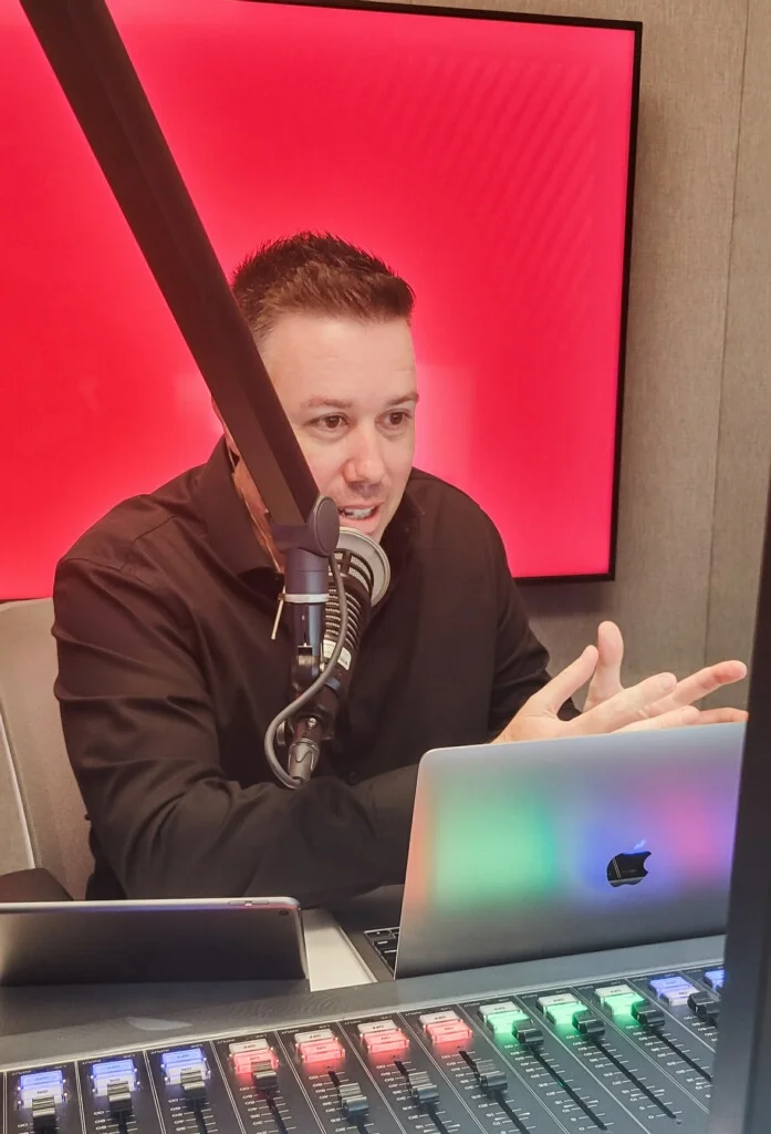 Ryan Gorman broadcasting in the radio studio, speaking into a microphone